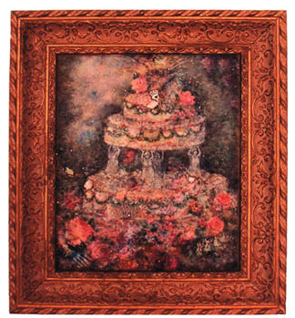 A tiered cake covered in pink roses inside a carved red and gold frame
